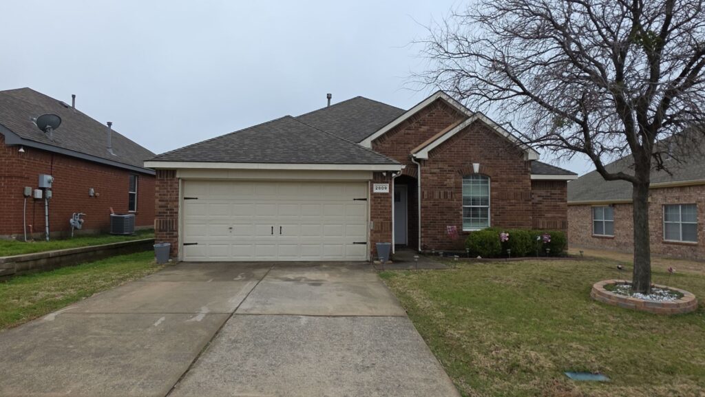 Front elevation of a brick ranch home with architectural shingles in Celina, Texas