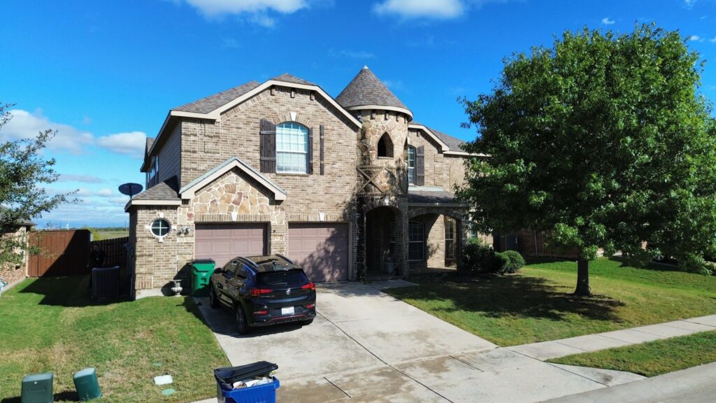 Two-story brick and stone home with a turret roof and architectural shingles in Celina, Texas