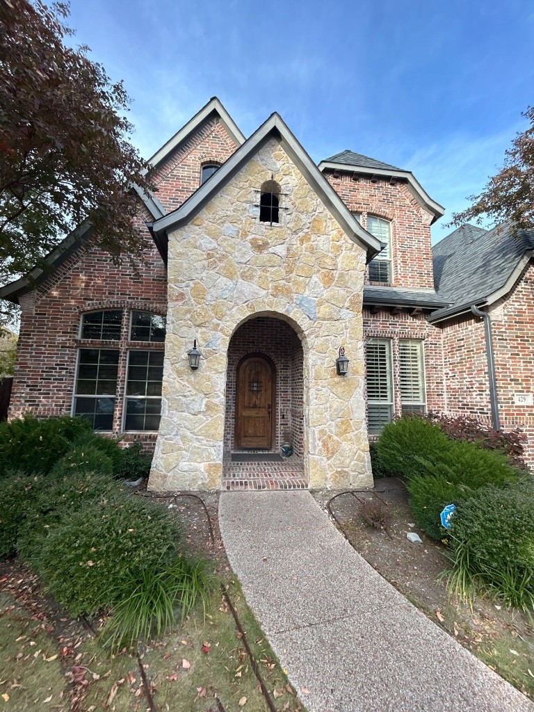 Brick and stone arched entry home elevation in Crescent Hill, Murphy, Texas
