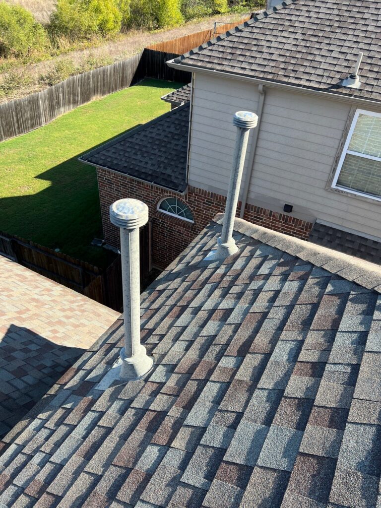 Close-up of a new architectural-shingle roof with two plumbing vents on a Celina, Texas home