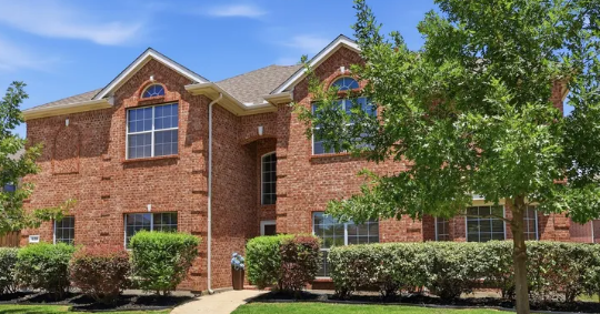 Two-story red brick multi-gable home in Gables at North Hill, Murphy, Texas