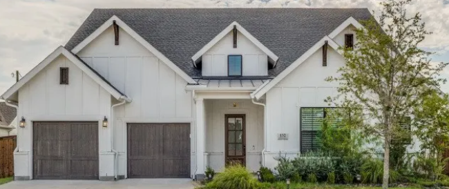 White modern farmhouse with dark garage doors in Glen Ridge Estates, Murphy, Texas