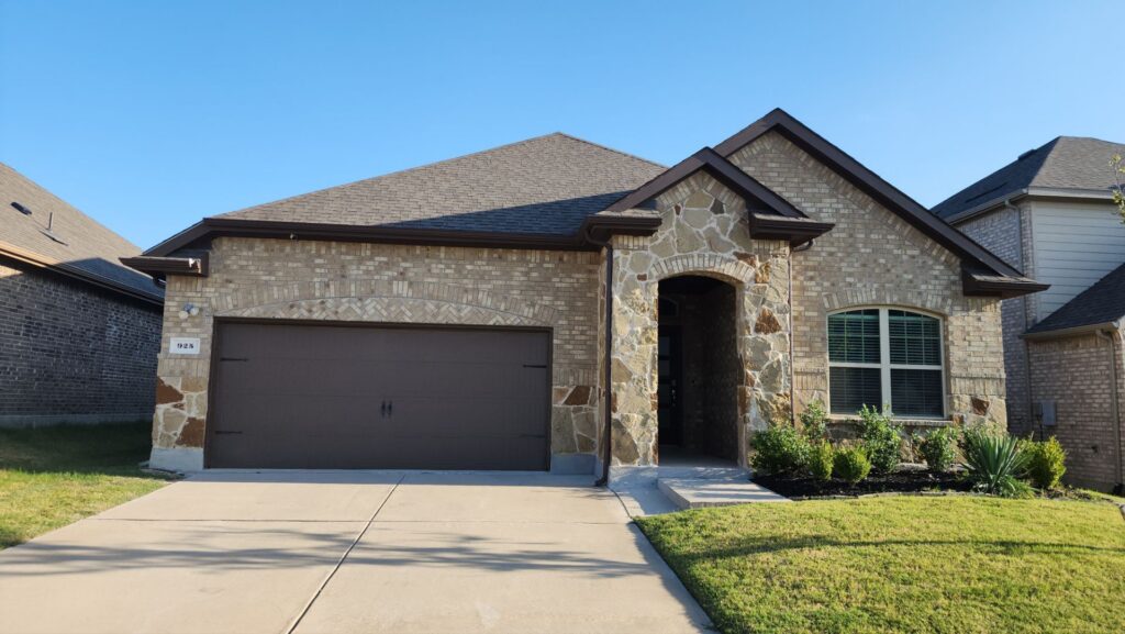 One-story brick-and-stone home with a brown architectural-shingle hip roof in Celina, Texas