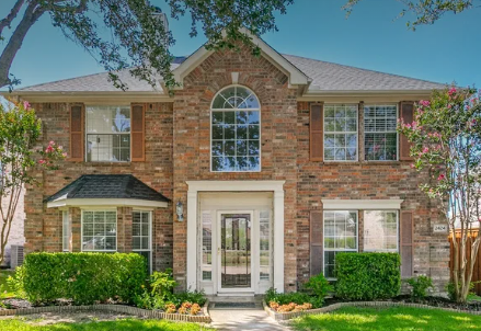 Two-story brick home with arched window in Knolls at Russell Creek, Plano, Texas