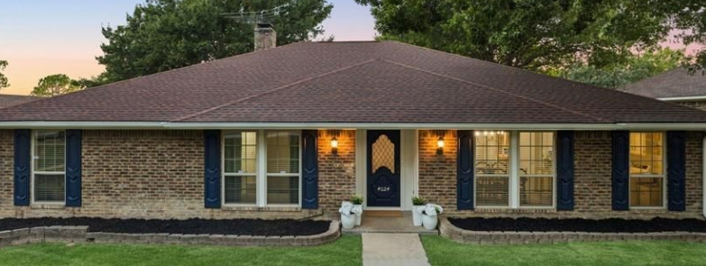 Brick ranch home with blue shutters at dusk in Los Rios, Plano, Texas