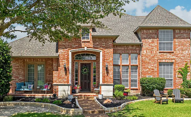 Two-story brick home with white stone arched entry in Murphy Meadows, Murphy, Texas