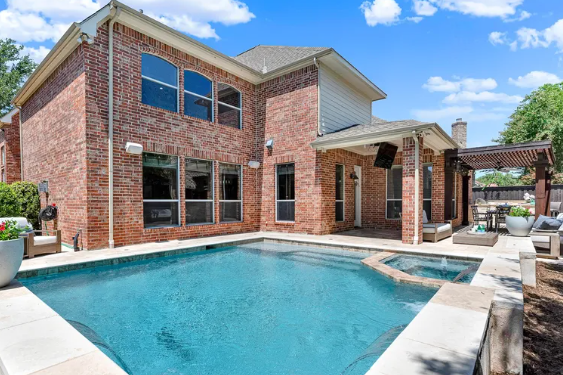 Brick home backyard with pool and patio in Preston Lakes, Plano, Texas