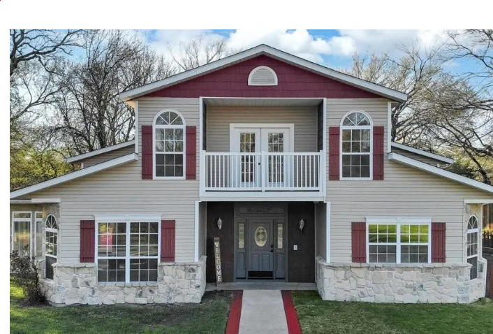 Two-story tan siding home with maroon shutters and stone base in Ryans Cove, Murphy, Texas