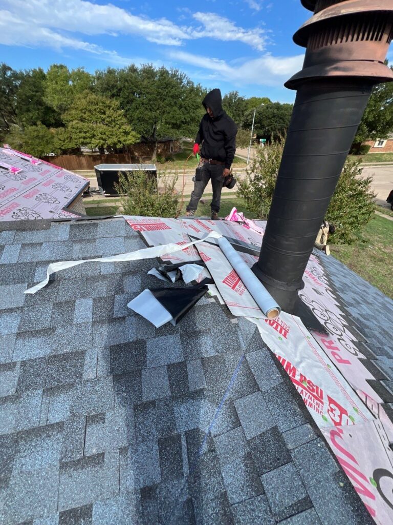 Roofer installing gray architectural shingles on an Allen, Texas home