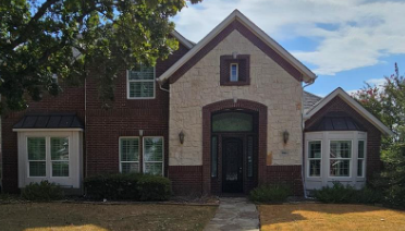 Two-story brick and stone home with bay windows in Stoney Hollow, Plano, Texas