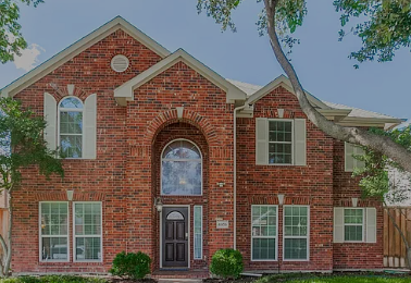 Two-story brick home with arched entry in Wellington at Preston Meadows, Plano, Texas